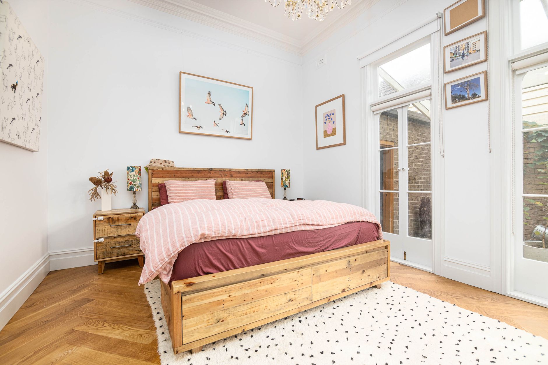 Bright bedroom with freshly painted walls, natural light, and rustic wood furniture